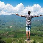 man in mountain green nature clouds