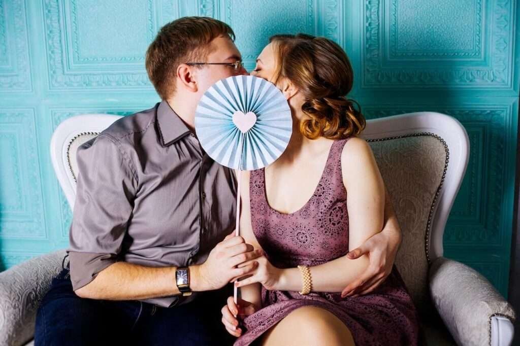 girl and boy kissing
covering face 
