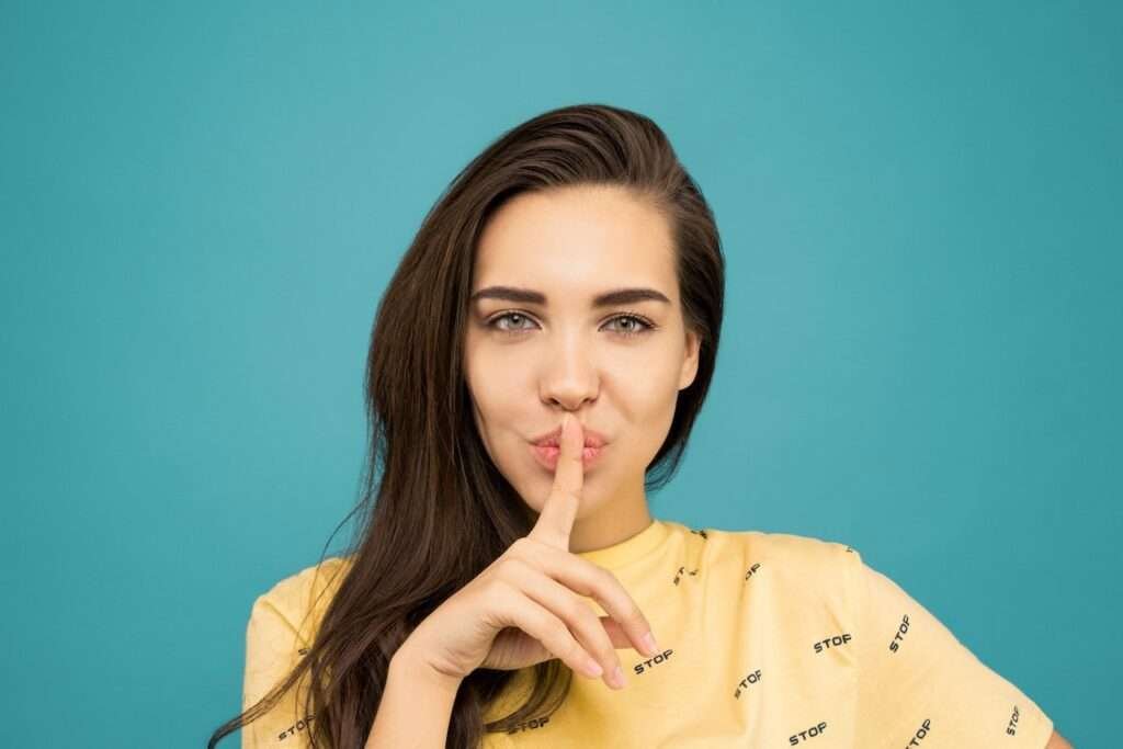 finger on mouth women secret